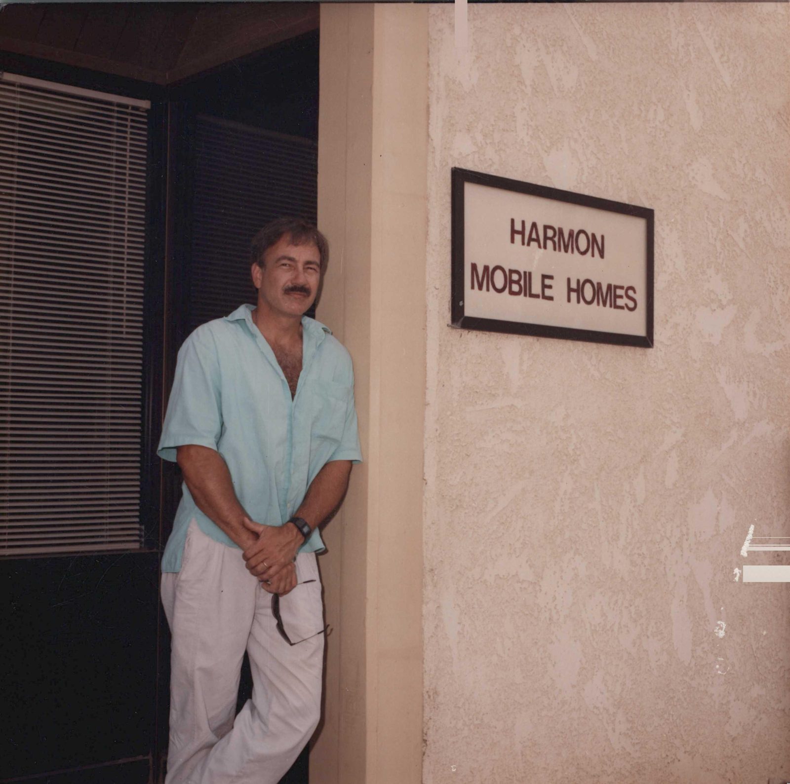 Robert Harmon beside the Harmon Mobile Homes sign